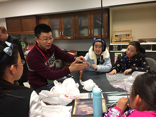 Yuan Shijun, a math teacher from Shanghai explains possible ways to protect a Barbie doll from a fall at UW-Stout