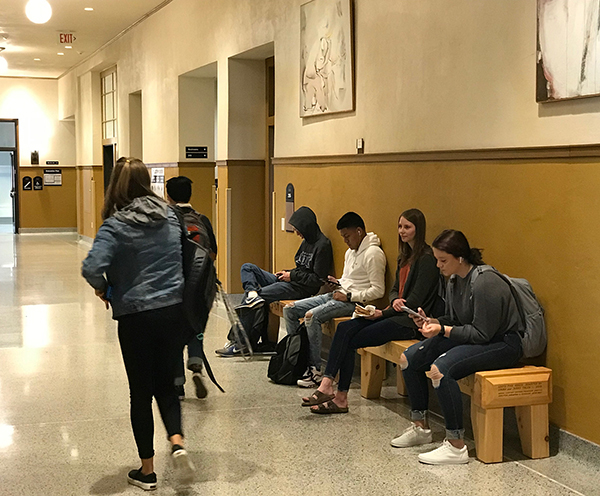 Students use the new historic-themed wood benches on the second floor of Harvey Hall at UW-Stout.