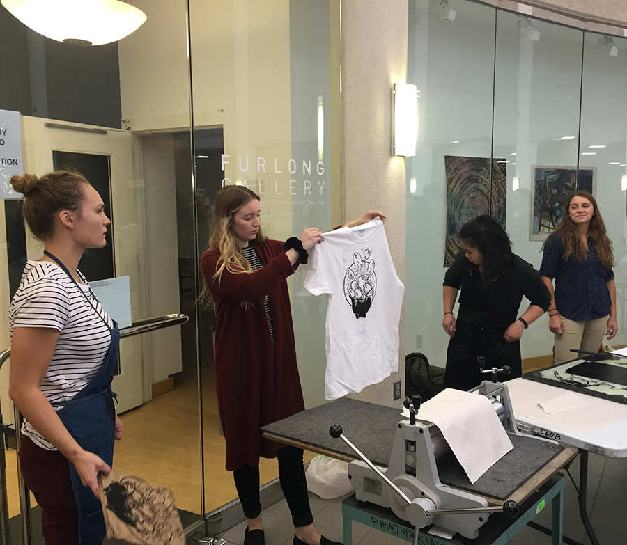 UW-Stout student Victoria Pesch holds up a finished t-shirt printed from wooden relief plates.