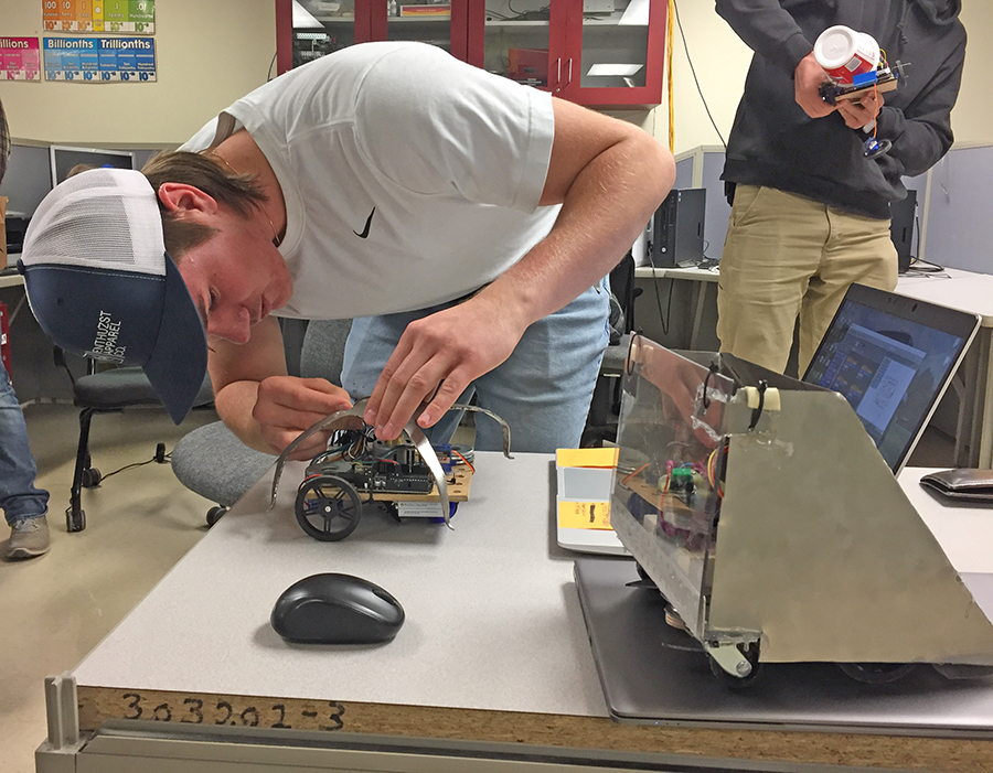 Kyle Olson works on repairing his bot the Jellyfish.