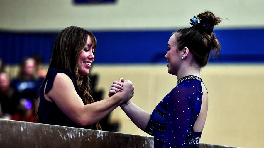 Carlie Beatty, right, is greeted by Chloe after a finishing a gymnastics routine for the Blue Devils.