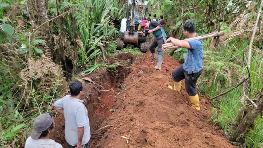 The students and villagers work on the water system pipeline, which is buried on the mountainside and will be about two miles long when finished.