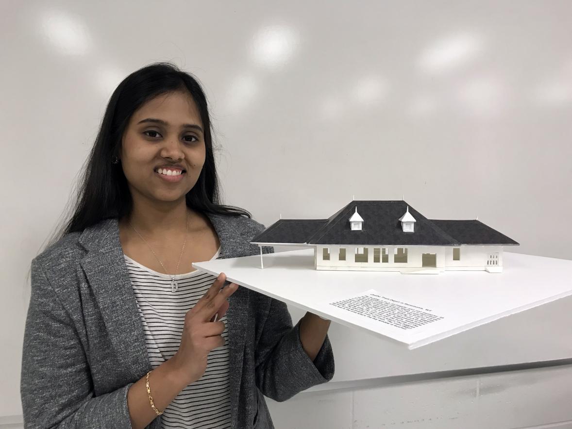 UW-Stout graduate Dharshana Gopalakrishnan holds a model of the Omaha depot. She used a 3D printer to create the model.