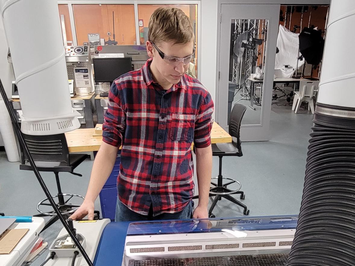 Thomas Shamla, a first-year UW-Stout student in mechanical engineering, operates a laser cutter and engraver in the Discovery Center Fab Lab as part of his Grow, Persist and Succeed campus job.