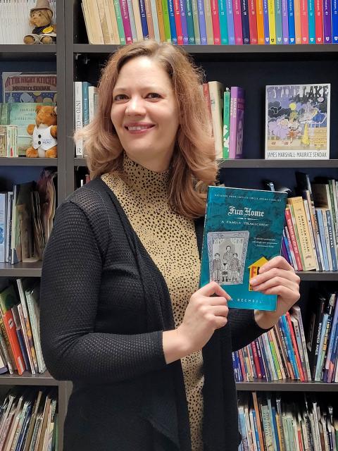 Associate professor Rickie-Ann Legleitner with a copy of "Fun Home"